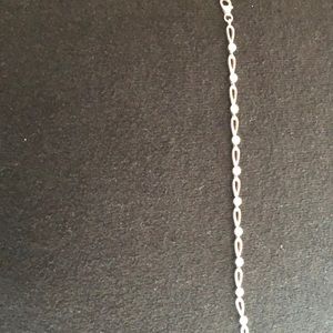 Silver bracket with diamond color stones